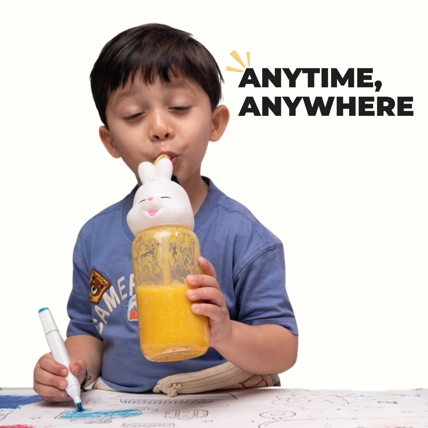 Boy drinking Yellow Smoothie Mix from bunny bottle while coloring