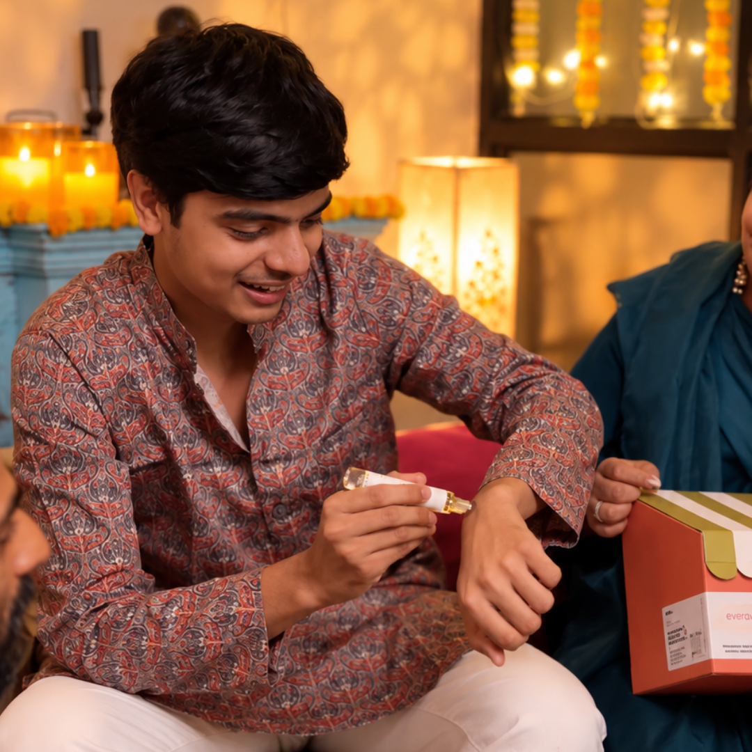 A man in a festive kurta applying a mood roll-on to his wrist during Diwali celebrations at home, a 10 ml perfume roller by A Creative Therapist, for external use only