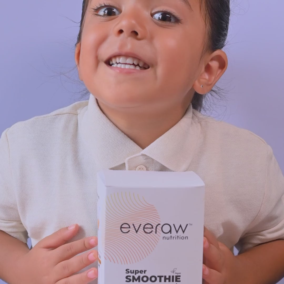A child tasting Everaw Smoothie Mix smoothies in pink, brown and yellow, with the Super Smoothie Mix pack of 5 box and all five smoothies in a row