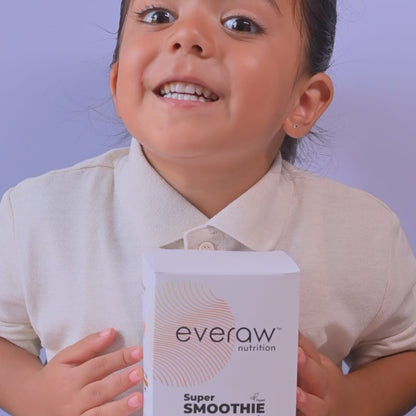 A child tasting Everaw Smoothie Mix smoothies in pink, brown and yellow, with the Super Smoothie Mix pack of 5 box and all five smoothies in a row