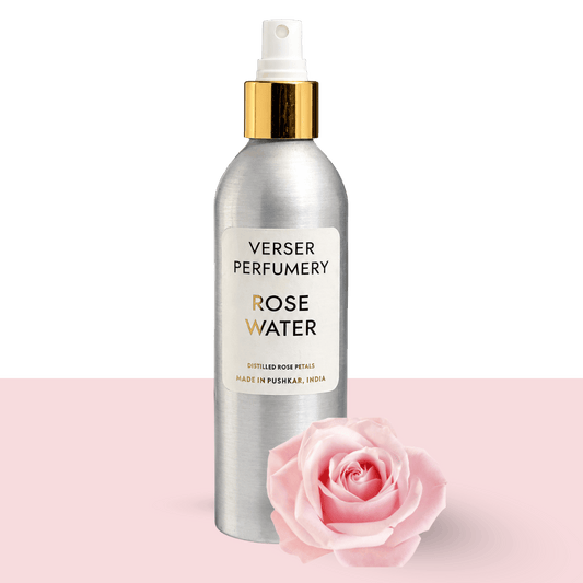 Verser Perfumery rose water in a silver spray bottle beside a pink rose, steam distilled from hand-harvested Pushkar roses by the traditional deg-bhapka method, a gentle floral hydrosol for skin and a Diwali gift from Rajasthan